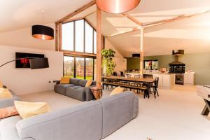 a living room with a couch and a table at Beautiful Barn Conversion Close To The Broads in Dilham