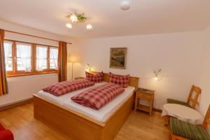 a bedroom with a large bed with red pillows at Hotel Binderhäusl in Berchtesgaden
