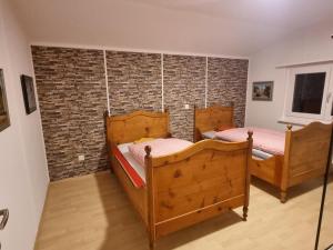 2 camas en una habitación con una pared de ladrillo en 24-7 Rooms en Sennwald
