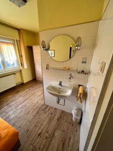 uma casa de banho com um lavatório e um espelho em Hotel-Heilsberg em Gottmadingen