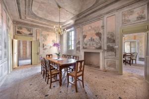 富馬內的住宿－Palazzo Montanari Art & Wine Luxury Apartments，一间带桌椅的用餐室