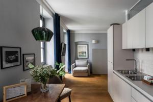 cocina y sala de estar con mesa y sofá en numa I Nora Apartments, en Salzburgo