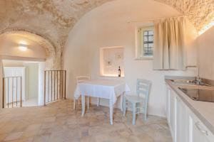 富馬內的住宿－Palazzo Montanari Art & Wine Luxury Apartments，一间厨房,里面配有桌椅