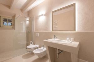 a bathroom with a sink and a toilet and a mirror at Palazzo Montanari Art & Wine Relais in Fumane