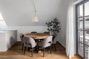ザルツブルクにあるnuma I Nora Apartmentsのダイニングルーム(木製テーブル、椅子付)