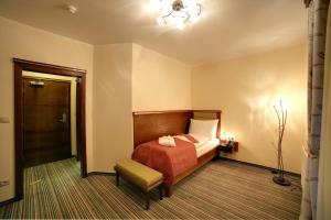 Pokój hotelowy z łóżkiem i krzesłem w obiekcie Parkhotel Forest w Mariańskich Łaźniach