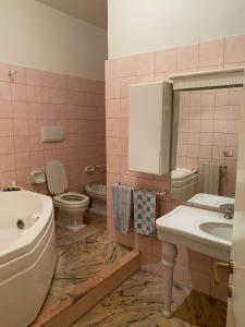 a pink bathroom with a sink and a toilet at VHOMETREVI in Rome