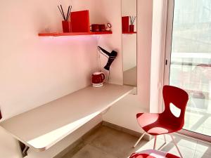 a desk and a red chair in a room at Central Private En-Suite with Balcony in shared residence in Tal-Pietà