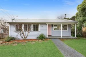 mały biały dom z trawnikiem w obiekcie Megalong Valley Lookout Cottage w mieście Katoomba