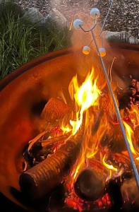 a fire in a pot with a hot dog on it at Megalong Valley Lookout Cottage in Katoomba