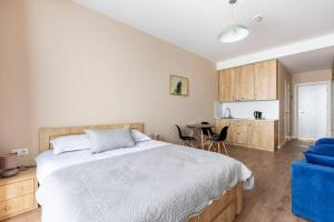 ein Schlafzimmer mit großem Bett und eine Küche in der Unterkunft New Gudauri, Alpic - Ski Resort at Your Doorstep - Stylish & Comfy Ski Apartment with ski-depot and Stunning Mountain Views in Gudauri