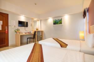 a hotel room with two beds and a desk at Tubtim Siam Suvarnabhumi Hotel in Bang Phli