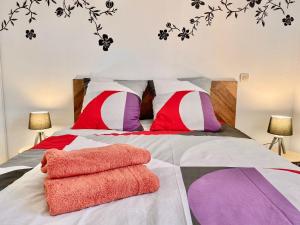 a bedroom with a bed with red white and purple pillows at Beaux Arts T3 Duplex, Rénové Lumineux + Garage in Montpellier