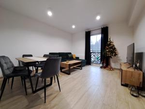 ein Wohnzimmer mit einem Tisch und einem Weihnachtsbaum in der Unterkunft ŁośHouse in Bytów