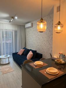 a living room with a blue couch and a table at Apartament KARMEL in Przemyśl