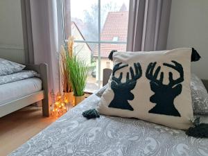Una cama con una almohada con dos manos en ella en ŁośHouse, en Bytów