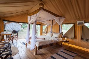 um quarto com uma cama de dossel numa tenda em Baobab Tented Camp em Kwa Kuchinia