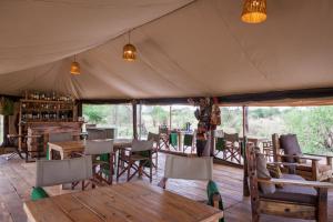 une salle à manger avec des tables et des chaises dans une tente dans l'établissement Baobab Tented Camp, à Kwa Kuchinia