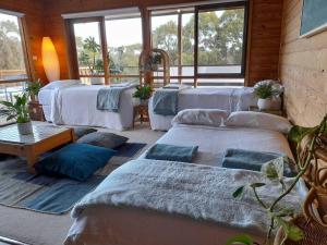 a room with four beds with blue pillows at Bells Beach Family Retreat in Bellbrae