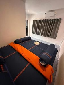um quarto com uma cama grande e um cobertor laranja em Divers House em Ko Tao