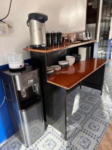 Divers House في كو تاو: مطبخ مع كونتر وطاولة مع آلة صنع القهوة