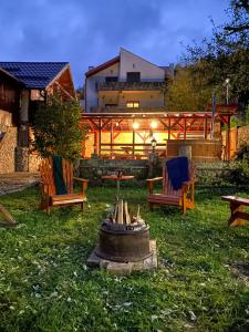 a backyard with chairs and a fire pit in the grass at Casa Aramis in Azuga +47 photos