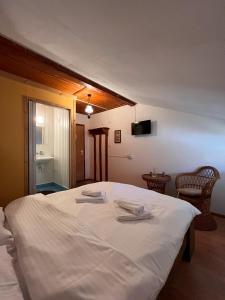 a bedroom with a white bed with two towels on it at Casa Aramis in Azuga