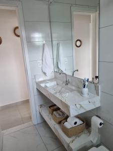 a bathroom with a sink and a mirror at Mar Doce Lar in Guaratuba