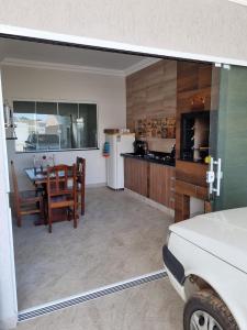 a kitchen and dining room with a table and a refrigerator at Mar Doce Lar in Guaratuba
