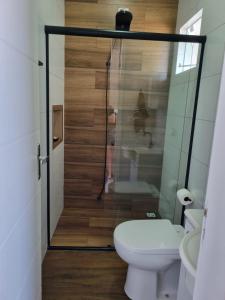 a small bathroom with a toilet and a shower at Mar Doce Lar in Guaratuba