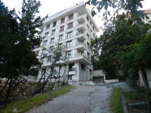 um edifício de apartamentos branco com uma rua de calçada em frente em Newly decorated Apartment close to Şişli metro in Istanbul em Istambul