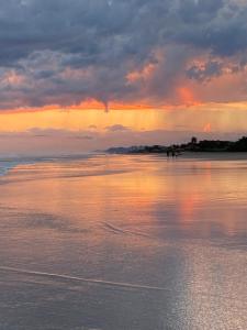 una puesta de sol en la playa con el agua en Casa de praia Suarão Beach, en Itanhaém