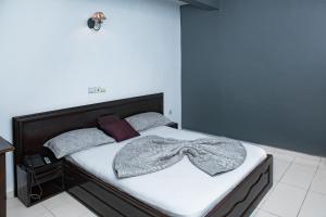 Un dormitorio con una cama con una manta. en krEMLin, en Douala