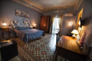 a bedroom with a bed and a table in a room at Bed and Breakfast Sotto le Stelle in Caltabellotta