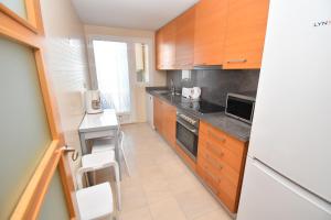 una cucina con armadi in legno, tavolo e sedie di Apartamento Golden Gardens a Jávea