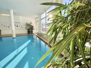 a large indoor swimming pool with a large plant at Hotel Garni Philipp in Serfaus