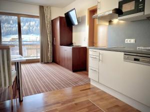 a kitchen with white cabinets and a large window at Hotel Garni Philipp in Serfaus
