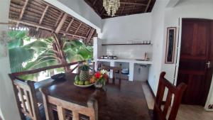 a kitchen and dining room with a table and chairs at Wonderful Ocean Villa in Jambiani