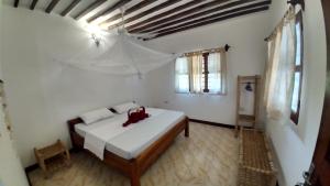 a bedroom with a bed with red shoes on it at Wonderful Ocean Villa in Jambiani