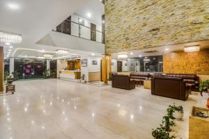 a lobby with a large stone wall and a waiting room at Hotel Kalka Royal in Katra