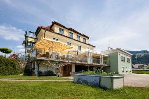 une grande maison avec un balcon sur une pelouse dans l'établissement Gasthof Schattleitner, à Brückl