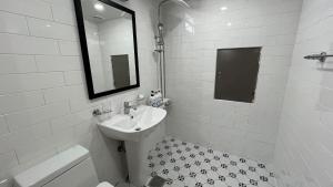 a white bathroom with a sink and a mirror at Tongyeong Chosun Hotel in Tongyeong