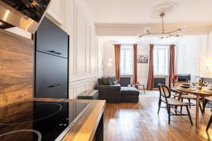 a kitchen and living room with a couch and a table at L' ALCOVE- Confort Charme Downtown in Dijon