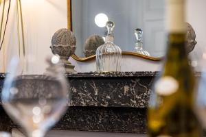a bottle of wine and a glass in front of a mirror at L' ALCOVE- Confort Charme Downtown in Dijon