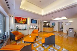 a living room with orange chairs and a lobby at Hotel Del Mare in Sorrento