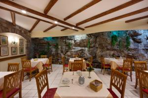 a restaurant with tables and chairs and a stone wall at Hotel Del Mare in Sorrento