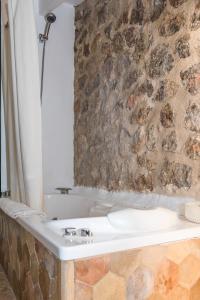 La salle de bains est pourvue d'un lavabo et d'un mur en pierre. dans l'établissement Mirabó de Valldemossa, à Valldemossa