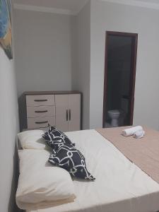 Un dormitorio con una cama con almohadas. en Apartamento.mutchisma5, en Porto Seguro