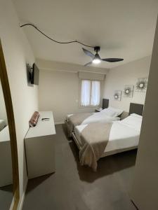 a bedroom with two beds and a ceiling fan at Lucia Holiday Apartments in Lazise