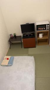 東京的住宿－Bessalov Home Japanese style room，客房设有1张床、1台电视和1张桌子。